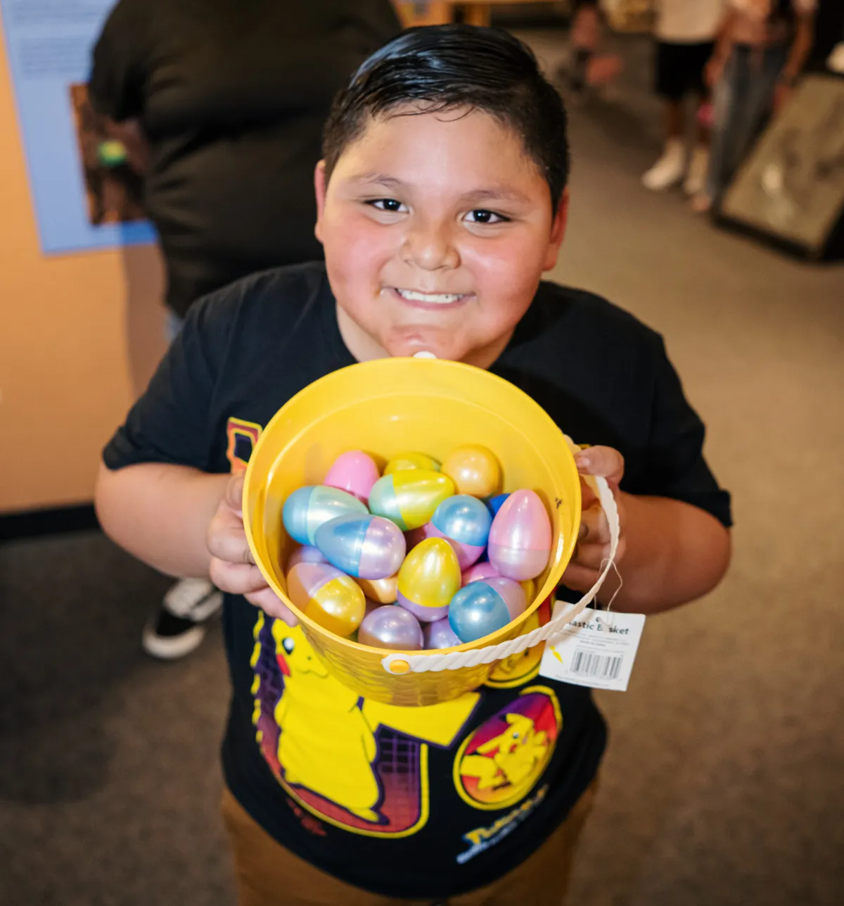 Young boy at AZMNH holding a basket full of the collected dinosaur eggs